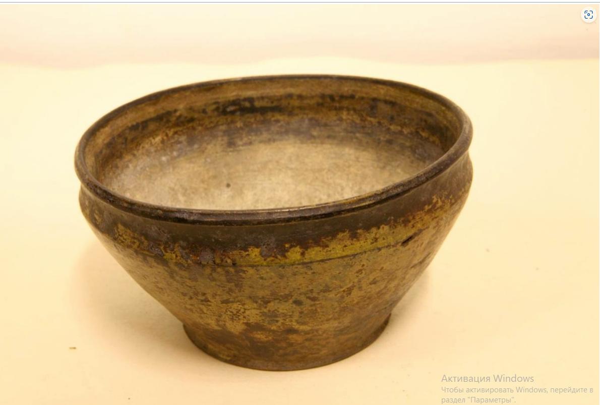 Керамическая миска коричневого цвета с широким горлом и утолщёнными краями. Поверхность покрыта пятнами имеет много потёртостей, внутри и снаружи заметен налёт времени