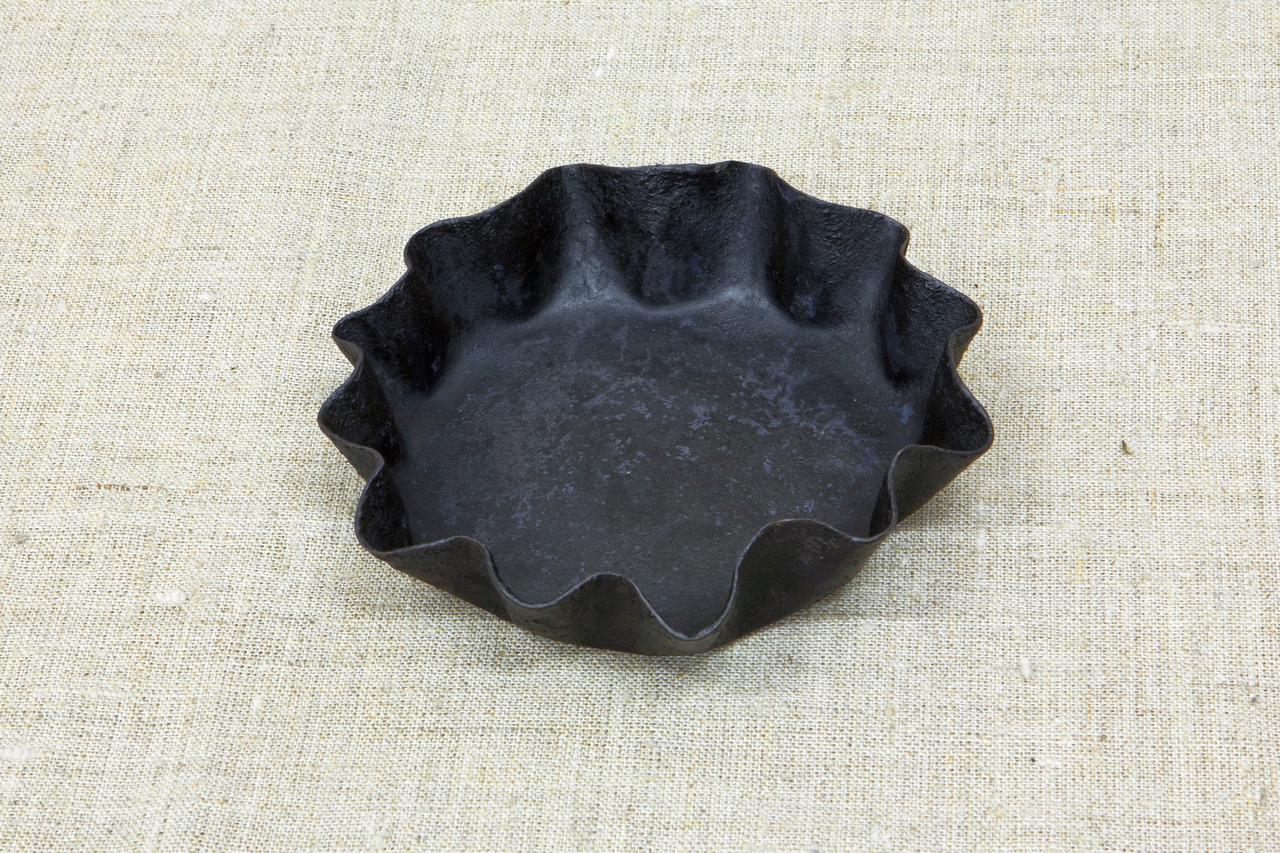 Чëрная круглая форма для выпечки с волнистыми краями, похожая на металлическую тарелку небольшой окружности