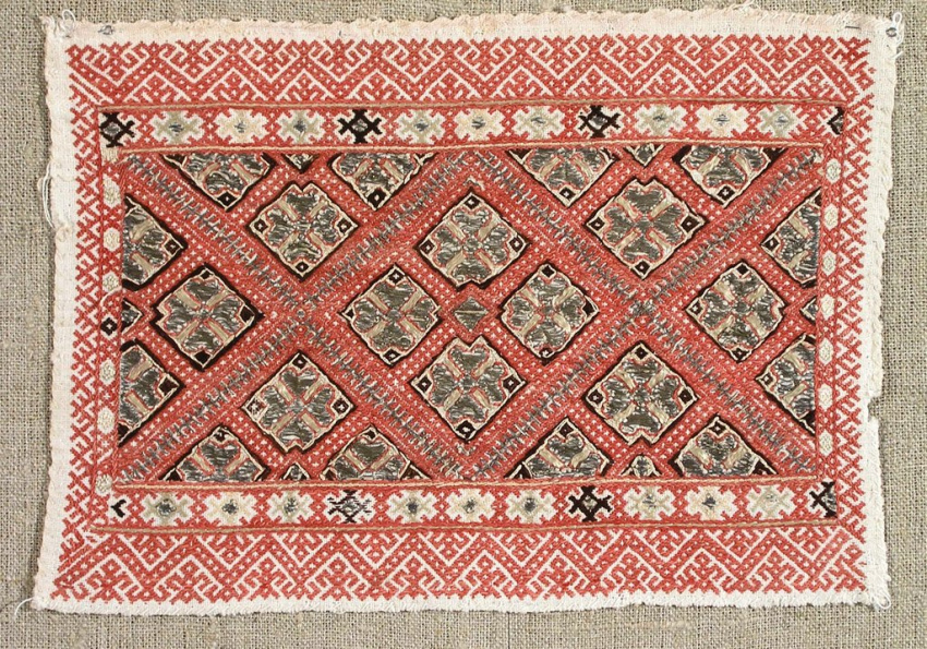 Прямоугольный ковёр. Основной цвет красный. В центре ромбами выложены крупные многоцветные узоры, разделённые диагональными красными полосами. По краям широкие бордюры с мелким геометрическим орнаментом и цветочными мотивами.