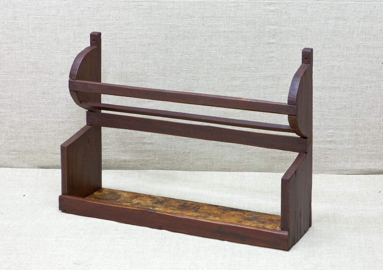 Настенная деревянная полка тёмного цвета с двумя рейками в верхней части и открытой нижней полкой. Боковые стороны прямоугольные с закруглёнными верхними углами